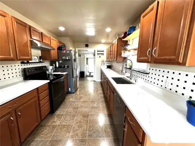 Renovated Spacious Alley Kitchen with Quartz Counters and Wood Cabinets