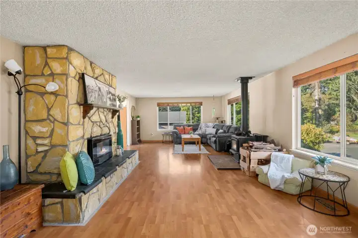 A spacious main-level living area greets you right off the front entry, featuring expansive picture windows that fill the space with natural light and showcase peaceful neighborhood views. The open layout allows for multiple seating zones or flexible configurations to suit different household needs.
