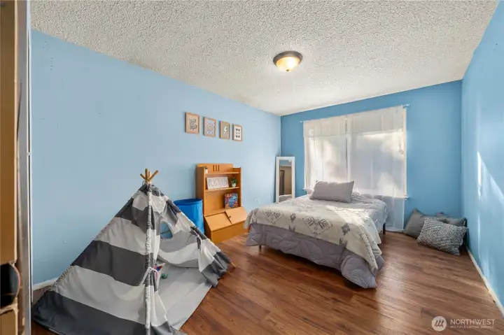 Spacious and bright, this upstairs bedroom features durable laminate flooring and a large window that fills the room with natural light. The generous size makes it versatile enough to serve as a relaxing retreat, guest space, or flex room—ideal for anyone wanting extra comfort and privacy on the upper level.