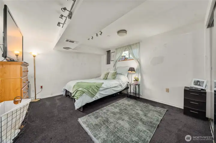 The lower-level bedroom offers a quiet and private retreat, complete with a large closet and natural light from the daylight window. Its location near the kitchenette and separate exterior access makes it ideal for guests, extended family, or anyone seeking added privacy within a multigenerational layout.
