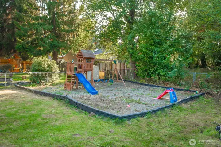 Dedicated play space complete with swing set and slide, bordered for safety and easy maintenance. A dream setup for outdoor fun with plenty of room to grow alongside your needs.