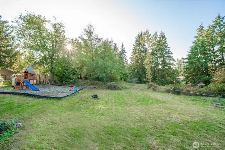 Expansive fenced yard with open lawn and wooded backdrop creates the perfect balance of play space and nature. The size and layout offer endless possibilities for gardens, gatherings, or future outdoor projects.