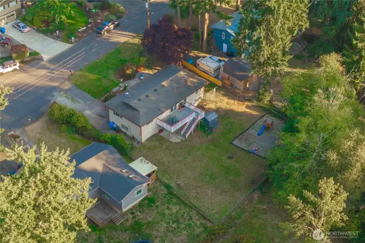 Bird’s-eye view highlighting the home’s spacious fenced backyard, elevated deck, and daylight basement layout. The lot offers both privacy and room to expand, set within a well-established residential community.