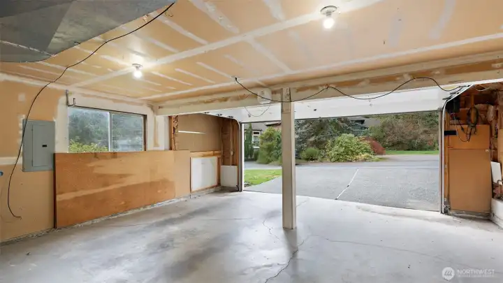 What a spacious garage! There’s plenty of room on each side of the door for shelving or storage, and still enough space to comfortably park two cars and open the doors with ease. It’s practical, roomy, and ready for all your gear.