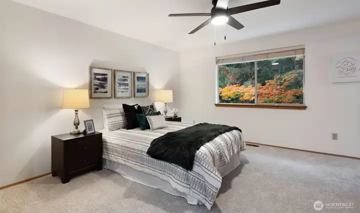 The primary bedroom feels open and inviting, with a brand-new ceiling fan overhead and a beautiful view of the greenery outside. It’s a peaceful retreat that makes winding down at the end of the day effortless.