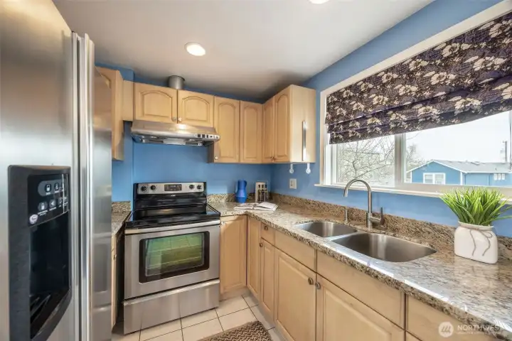 Updatd kitchen with stainless steel appliances, and a double sink that overlooks the back yard.