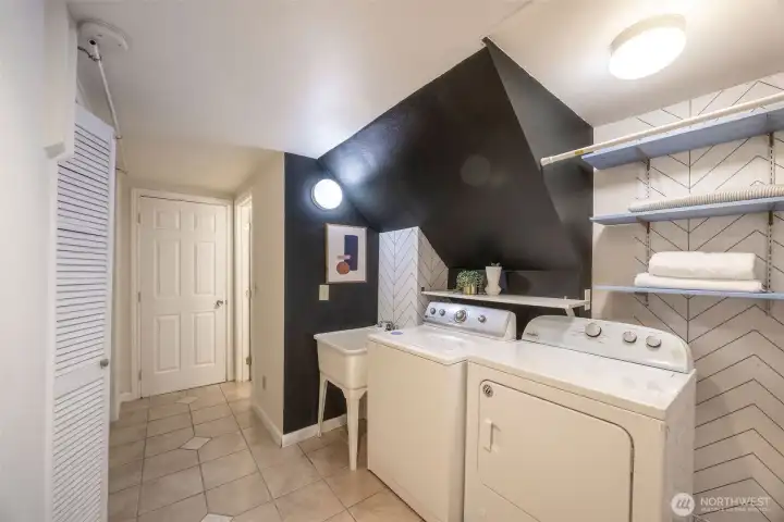 Lower hallway laundry area with convenient laundry sink. Far door leads to the garage.