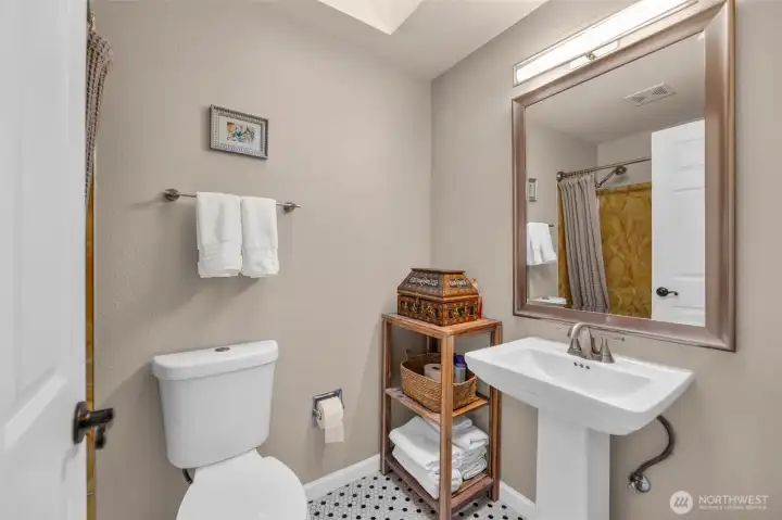 The full bath off the hallway has new tile flooring, skylight and more