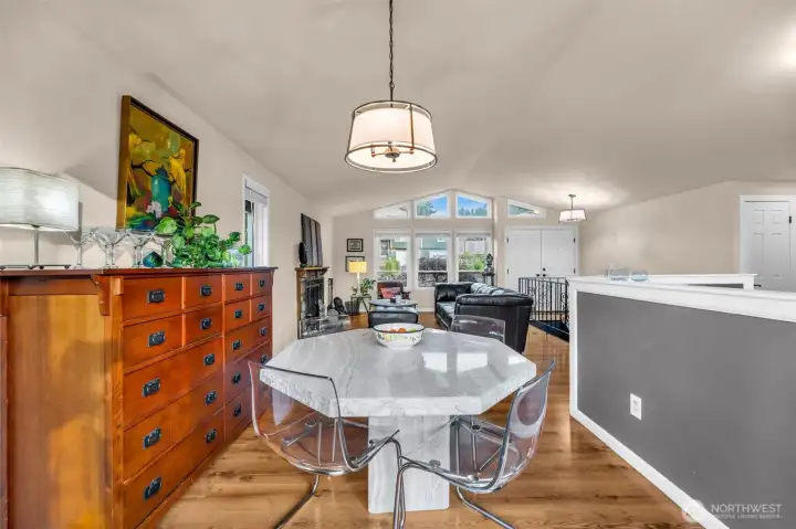 View from the back door looking onto the dinning, open kitchen to the right and living room. Vaulted ceiling and lots of windows open this up.