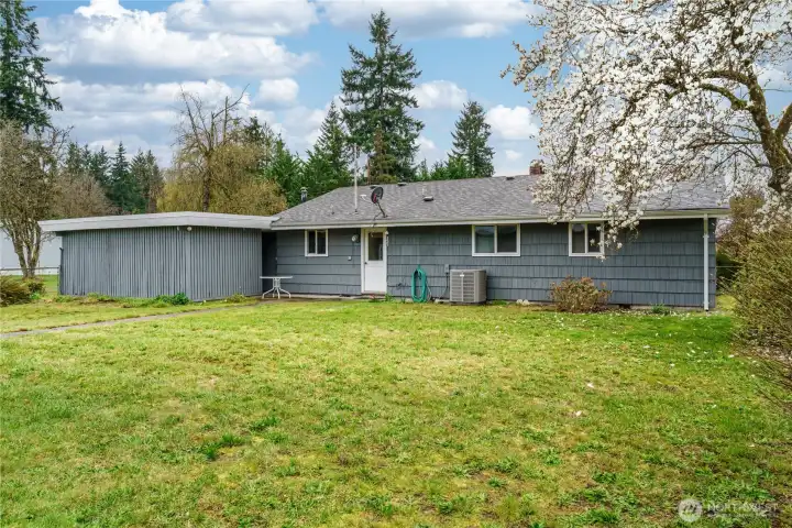 Large, flat backyard showing heat pump. Beautiful Dogwood tree. Large, flat backyard showing heat pump. Beautiful Dogwood tree.