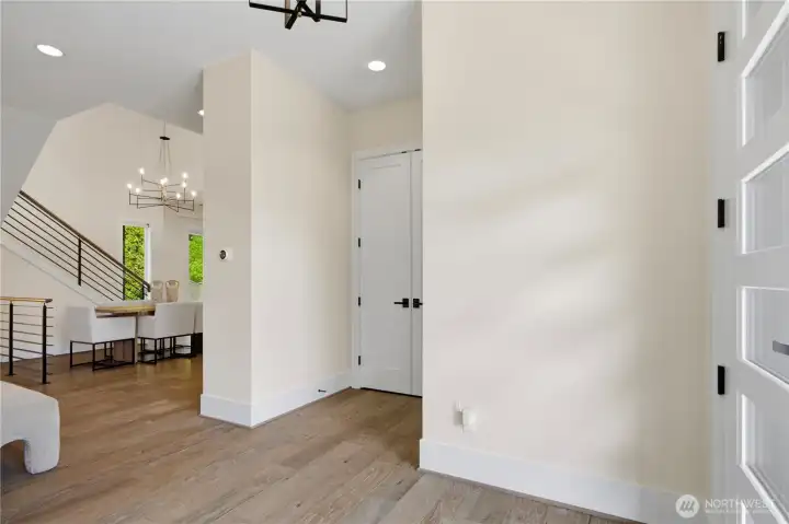 Main-level front entry with double doors concealing a conveniently located coat closet for added storage and organization