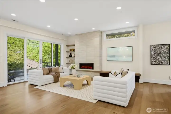 Living room features gas fireplace, tile surround, floating shelves and large sliding glass doors for easy indoor outdoor living