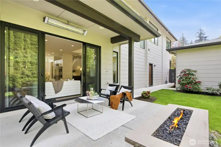 Covered patio with ceiling heaters and gas firepit—designed for year-round enjoyment