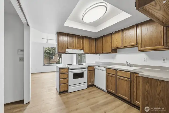 Kitchen offers plenty of counter space and wood cupboards.