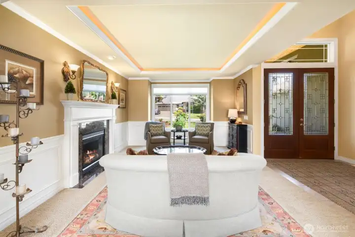 Living room off entry with coved ceilings, recessed lighting, gas fireplace and high-end finishes throughout.
