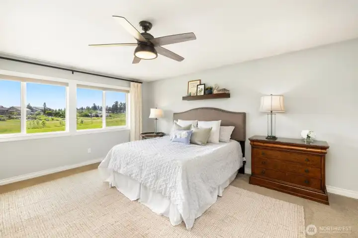 Gorgeous views from the primary suite!  Motorized blinds, custom draperies and generous spaces make this room feel like luxury resort living every day!