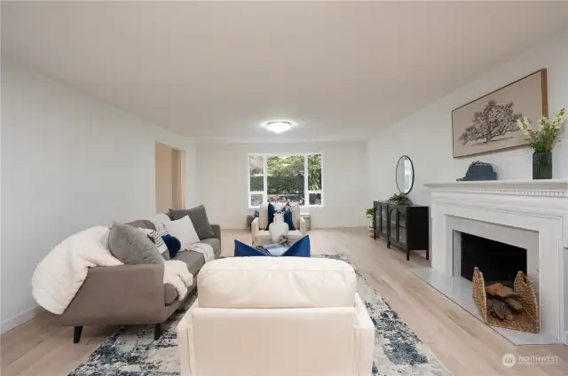 Huge bay window brings in the sunshine while opening up to the manicured front yard