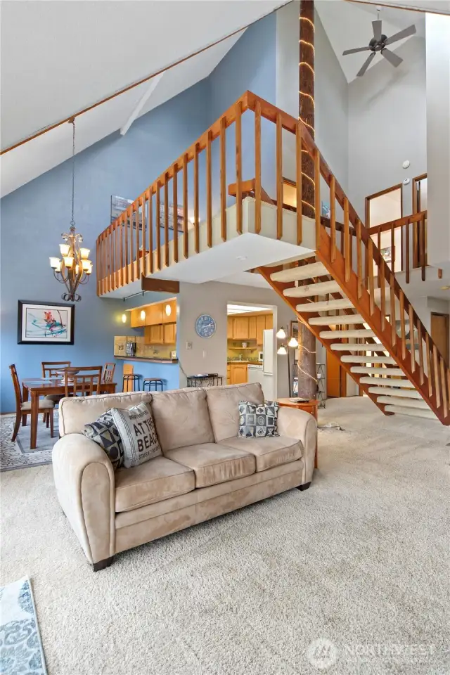 Living room w/ loft area above open kitchen.