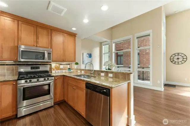 This spacious kitchen includes gas stove, granite counters and stainless steel appliances.