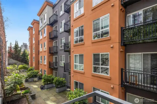 A rare urban perk: this spacious shared patio is lined with greenery and tucked away for peace, privacy, and fresh air without ever leaving home.