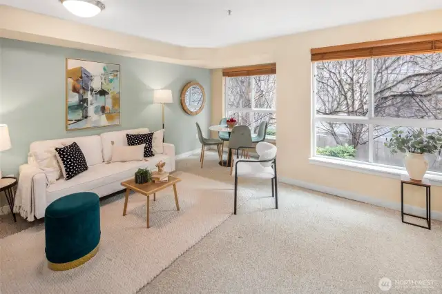 Natural light pours into this cheerful living space, offering room to lounge, dine, and enjoy peaceful, tree-filled views.