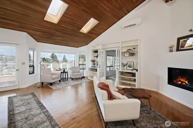 A little more perspective. Wood at your feet and above without any sense of "too dark". Cozy up to your propane fireplace. Lots of built in book shelves. The hallway to the main level primary suite, bedroom and office is to your back.