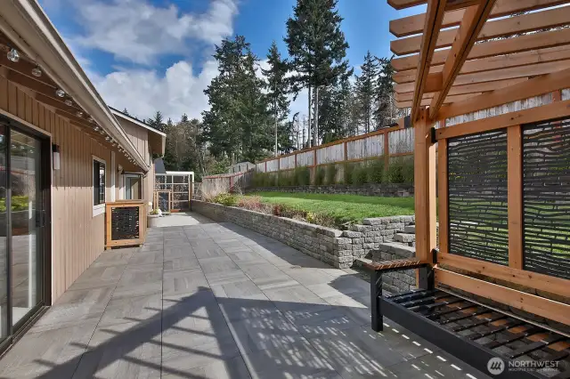 New retaining wall and expansive concrete deck with pergola w/benches (cushions included, not in photo) provide plenty of space for entertaining or for your own personal enjoyment. Back yard is fenced and was replaced during Seller's ownership.