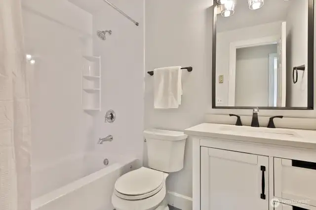 Remodeled full guest bath. You can see the doorway to the 3rd bedroom reflected in the mirror.