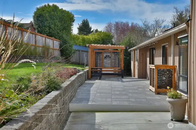 During Seller's ownership, this concrete patio, retaining wall & pergola with bench seating were added. There is a garden shed on the other side of the pergola. Glass doors connect you to the dining area of the kitchen and the dining Room.