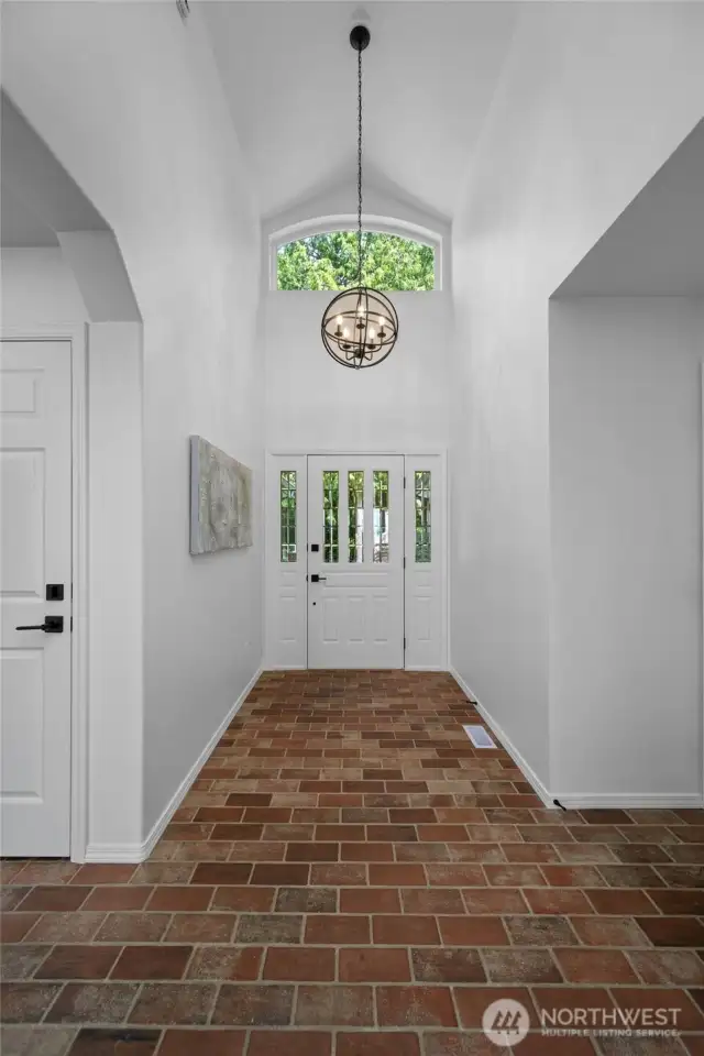 Grand entry with soaring ceilings, transom window, and rich brick flooring makes a stunning first impression.    Grand entry with soaring ceilings, transom window, and rich brick flooring makes a stunning first impression.    Grand entry with soaring ceilings, transom window, and rich brick flooring makes a stunning first impression.