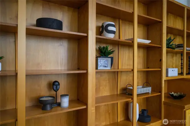 A living room wall of custom built-in shelving offers elegant display and storage space—perfect for showcasing your personal style.