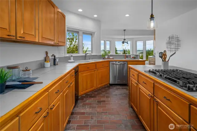 A kitchen made for gathering—gas range island, stainless appliances, generous storage, and views that turn cooking into a joy.