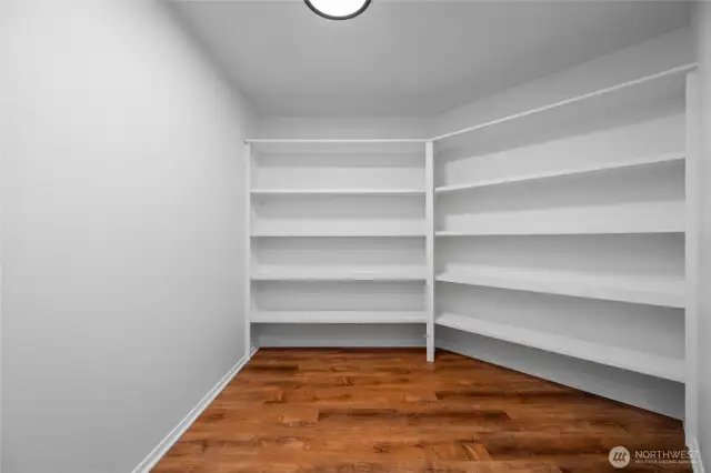 With room for an additional freezer, this spacious walk-in pantry with custom shelving offers incredible storage and organization for all your kitchen essentials.