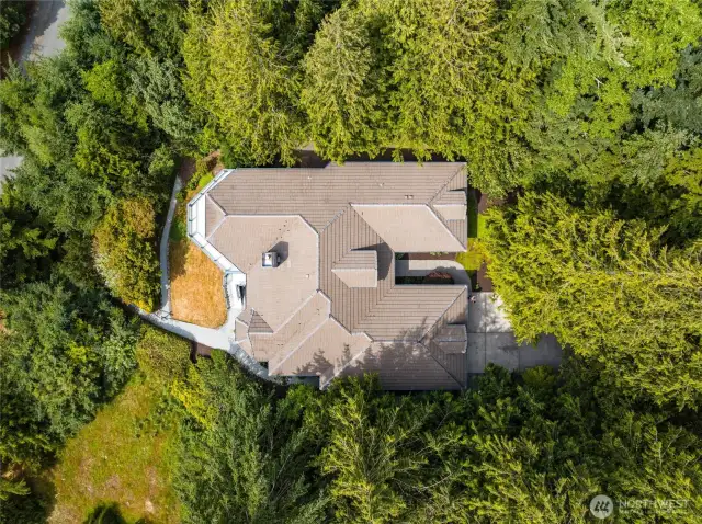 Distinctive architectural roofline and private wooded surroundings make this custom home a true Northwest sanctuary.