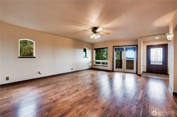 Large living room with french doors to head out to the front patio or down the steps to the outdoor  fireplace!