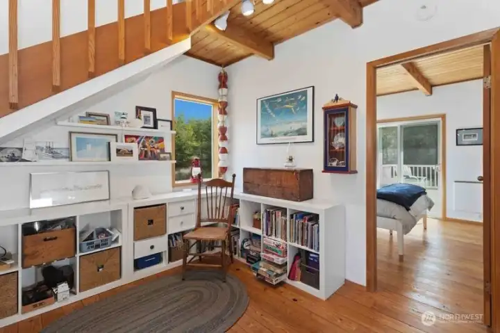 A charming nook beneath the stairs offers a creative space for projects, reading, or display.