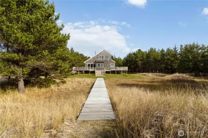 Native shore pines and rolling dunes create a tranquil and protected coastal environment.