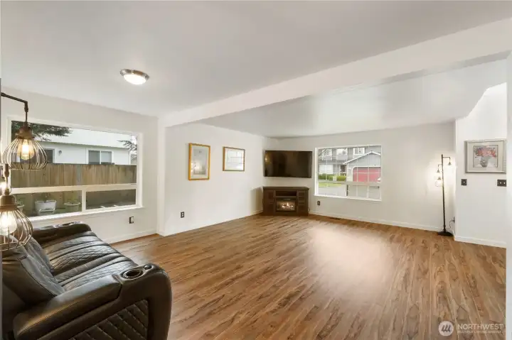 Here is second view of oversized newly painted living and dining rooms off entry with lots of natural light and low maintenance lvp fooring