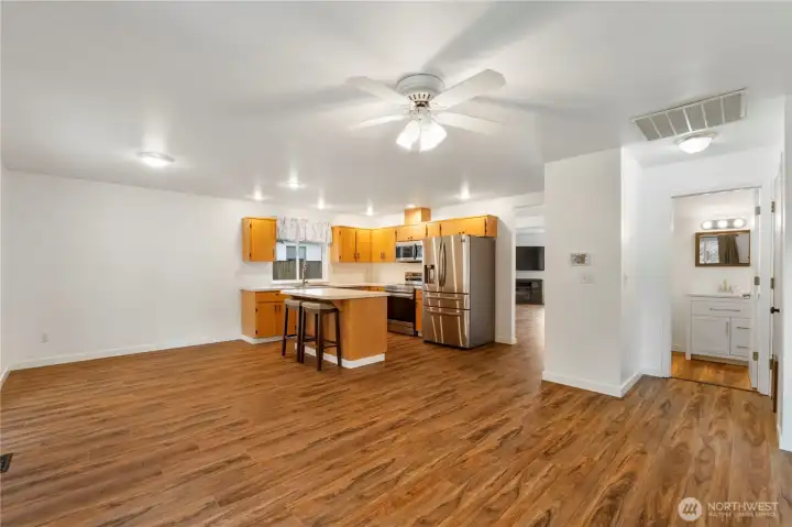 Looking back from family room into kitchen half bath and living rooms.  There is all new bright white paint through out home
