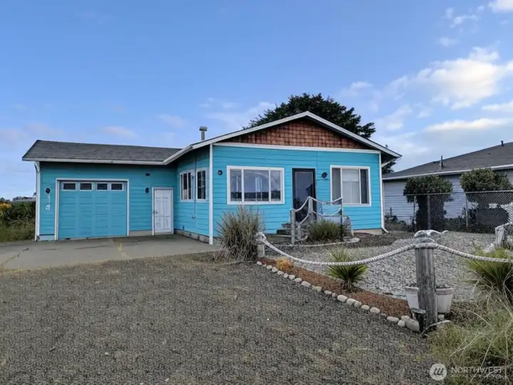 Coastal cottage with low maintenance, beachy vibes landscaping. Extra wide garage has a handy utility sink and is extra wide for easy parking and storage.