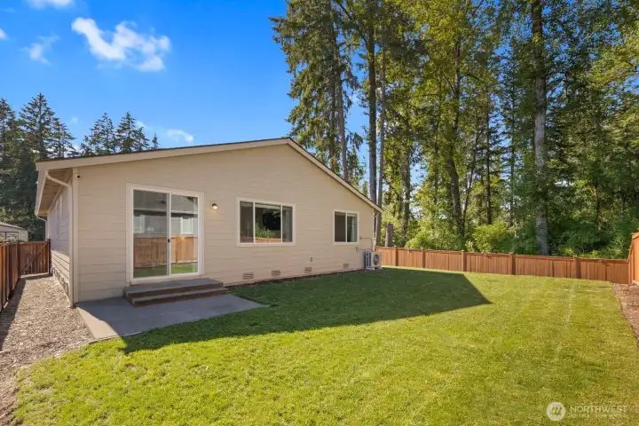 The backyard offers a great balance of usable lawn space and privacy, creating an inviting extension of the home's indoor living areas.