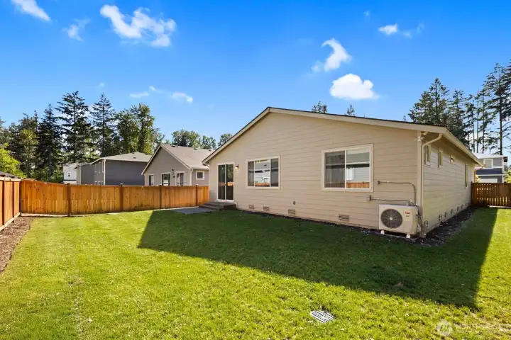 Large windows and a sliding glass door connect the interior living spaces to the backyard, making it easy to enjoy indoor-outdoor living throughout the year.