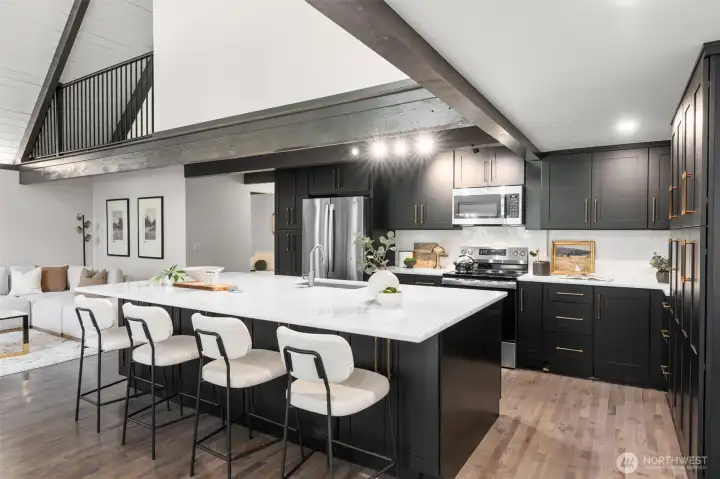 The impeccably designed kitchen is a chef's dream, boasting an abundance of sleek cabinetry, subtle under-cabinet task lighting, and premium matching stainless steel appliances. Expansive white quartz countertops provide endless prep space and wrap into a massive island perfect for casual dining. With fluid transition from the kitchen to the main living area, this light-filled home is an absolute masterpiece for both entertaining and luxurious daily living.