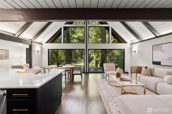 Experience the ultimate in open-concept living in this breathtaking contemporary residence. The centerpiece of the home is a dramatic great room defined by soaring wood ceilings with exposed architectural beams and an expansive wall of windows that seamlessly connects the indoors with nature.    Step into a space designed to take your breath away. This spectacular open-concept great room effortlessly pairs bold, contemporary lines with the organic warmth of soaring, all-wood beamed ceilings. But the true showstopper is the massive wall of windows—featuring 20-foot wide sliding glass doors that effortlessly glide open to blur the line between inside and out. The entire space flows seamlessly onto a huge custom deck, creating an unparalleled layout for summer entertaining or peaceful morning coffees. At the heart of it all sits a gourmet chef’s kitchen, complete with quartz countertops, an abundance of sleek cabinetry, glowing under-cabinet lighting. This is a "home experience"!
