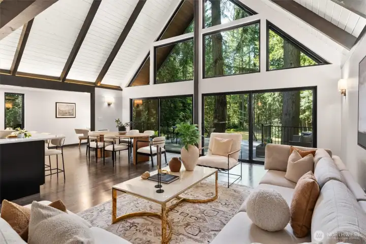 Experience the ultimate in open-concept living in this breathtaking contemporary residence. The centerpiece of the home is a dramatic great room defined by soaring wood ceilings with exposed architectural beams and an expansive wall of windows that seamlessly connects the indoors with nature.    Step into a space designed to take your breath away. This spectacular open-concept great room effortlessly pairs bold, contemporary lines with the organic warmth of soaring, all-wood beamed ceilings. But the true showstopper is the massive wall of windows—featuring 20-foot wide sliding glass doors that effortlessly glide open to blur the line between inside and out. The entire space flows seamlessly onto a huge custom deck, creating an unparalleled layout for summer entertaining or peaceful morning coffees. At the heart of it all sits a gourmet chef’s kitchen, complete with quartz countertops, an abundance of sleek cabinetry, glowing under-cabinet lighting. This is a "home experience"!