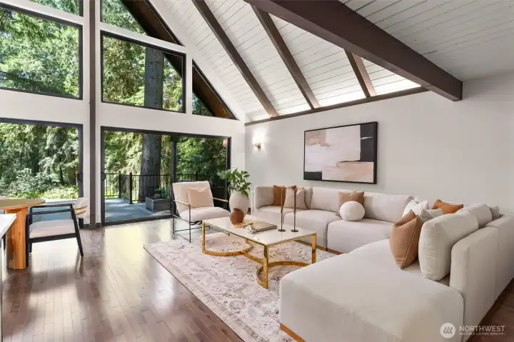 Experience the ultimate in open-concept living in this breathtaking contemporary residence. The centerpiece of the home is a dramatic great room defined by soaring wood ceilings with exposed architectural beams and an expansive wall of windows that seamlessly connects the indoors with nature.    Step into a space designed to take your breath away. This spectacular open-concept great room effortlessly pairs bold, contemporary lines with the organic warmth of soaring, all-wood beamed ceilings. But the true showstopper is the massive wall of windows—featuring 20-foot wide sliding glass doors that effortlessly glide open to blur the line between inside and out. The entire space flows seamlessly onto a huge custom deck, creating an unparalleled layout for summer entertaining or peaceful morning coffees. At the heart of it all sits a gourmet chef’s kitchen, complete with quartz countertops, an abundance of sleek cabinetry, glowing under-cabinet lighting. This is a "home experience"!