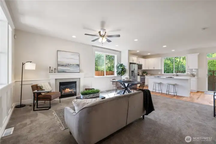Open living area with a cozy gas fireplace and natural light pouring in from multiple windows.