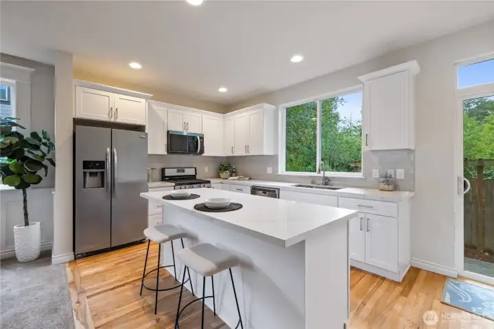 Kitchen with white cabinetry, island seating, and stainless appliances — great prep and entertaining space.