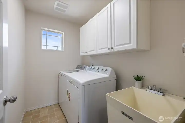Laundry room with included washer & dryer — notice the built-in upper cabinet for extra storage