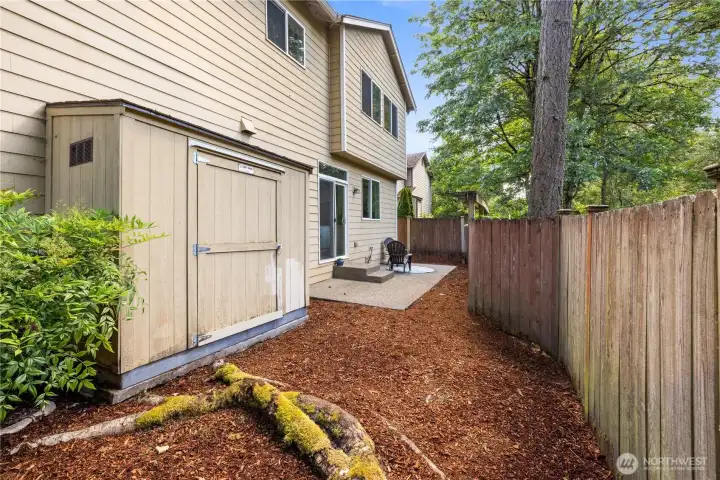 Storage shed tucked neatly into the corner of the yard — more space than it looks from the outside.